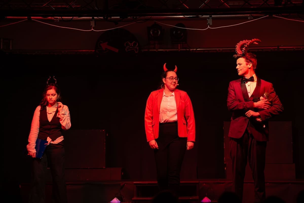 Prof. Dr. Dr. Glutheiß (Nora) beratschläggt den Teufel und seine Assistantentin (Fernanda).