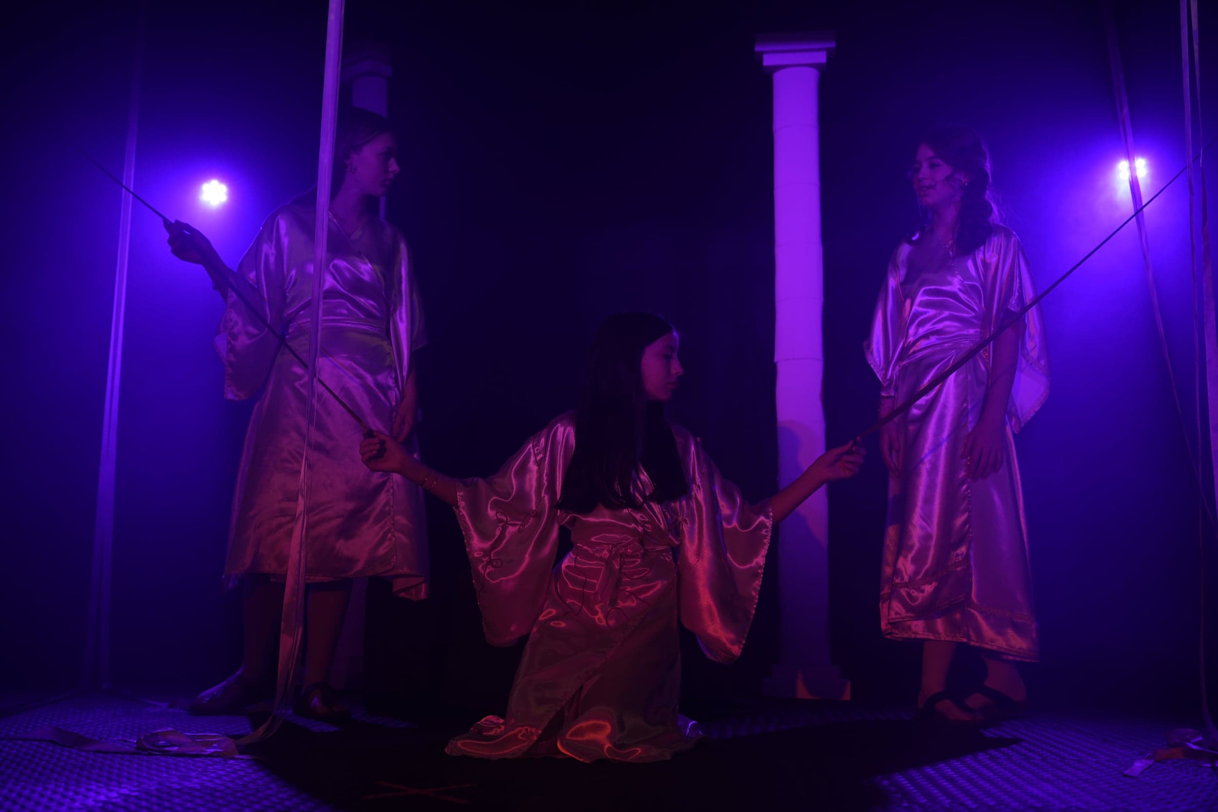 Klotho (Sophie) kniet in der Mitte, während Lachesis (Lina) und Atropos (Nela) den goldenen Faden halten.